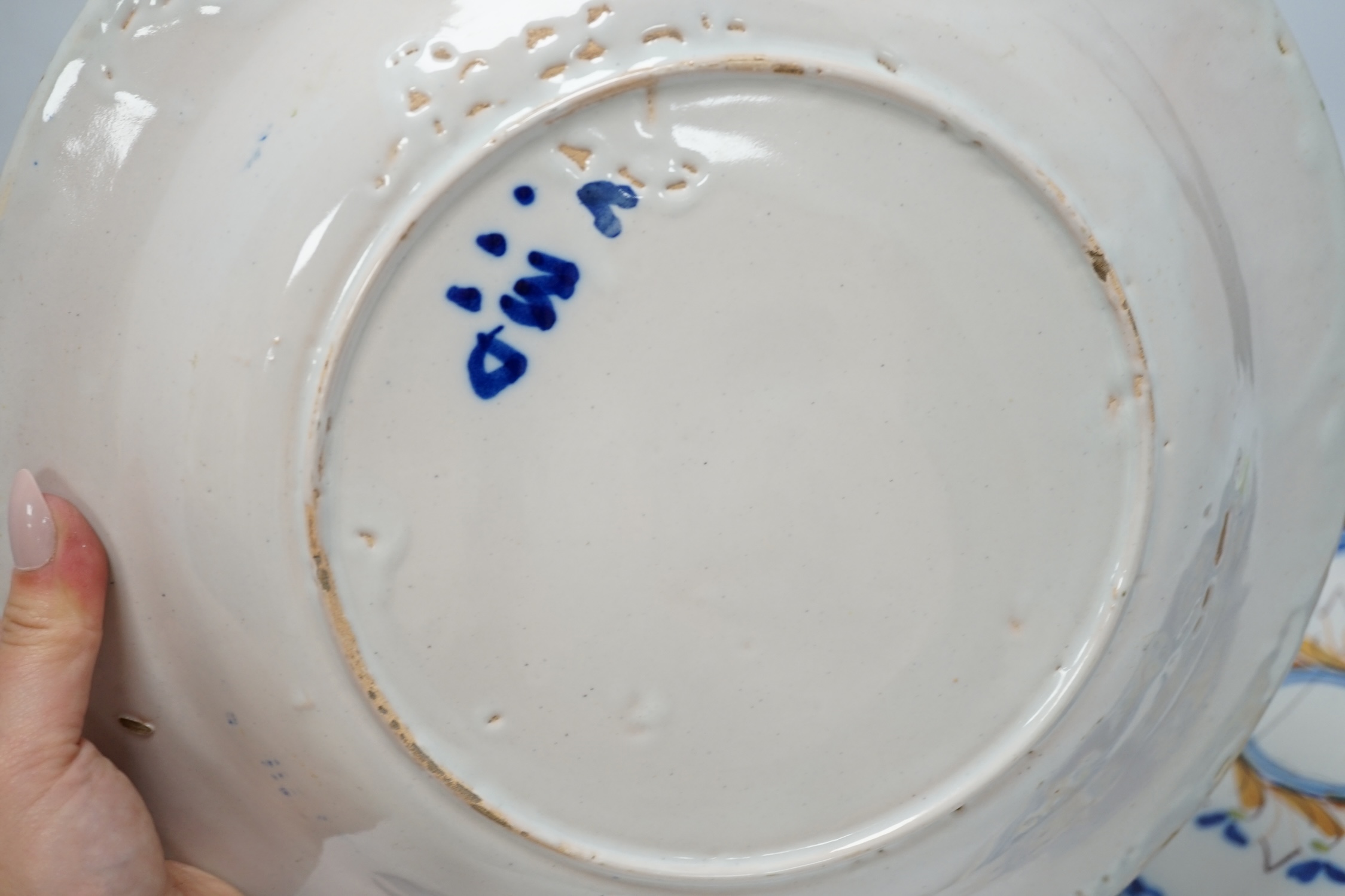 A Delft blue and white plaque, two continental tin-glazed dishes, one signed V.M.D, and a Booths scale-blue bowl, largest 35cm in diameter. Condition - largest dish poor, others fair